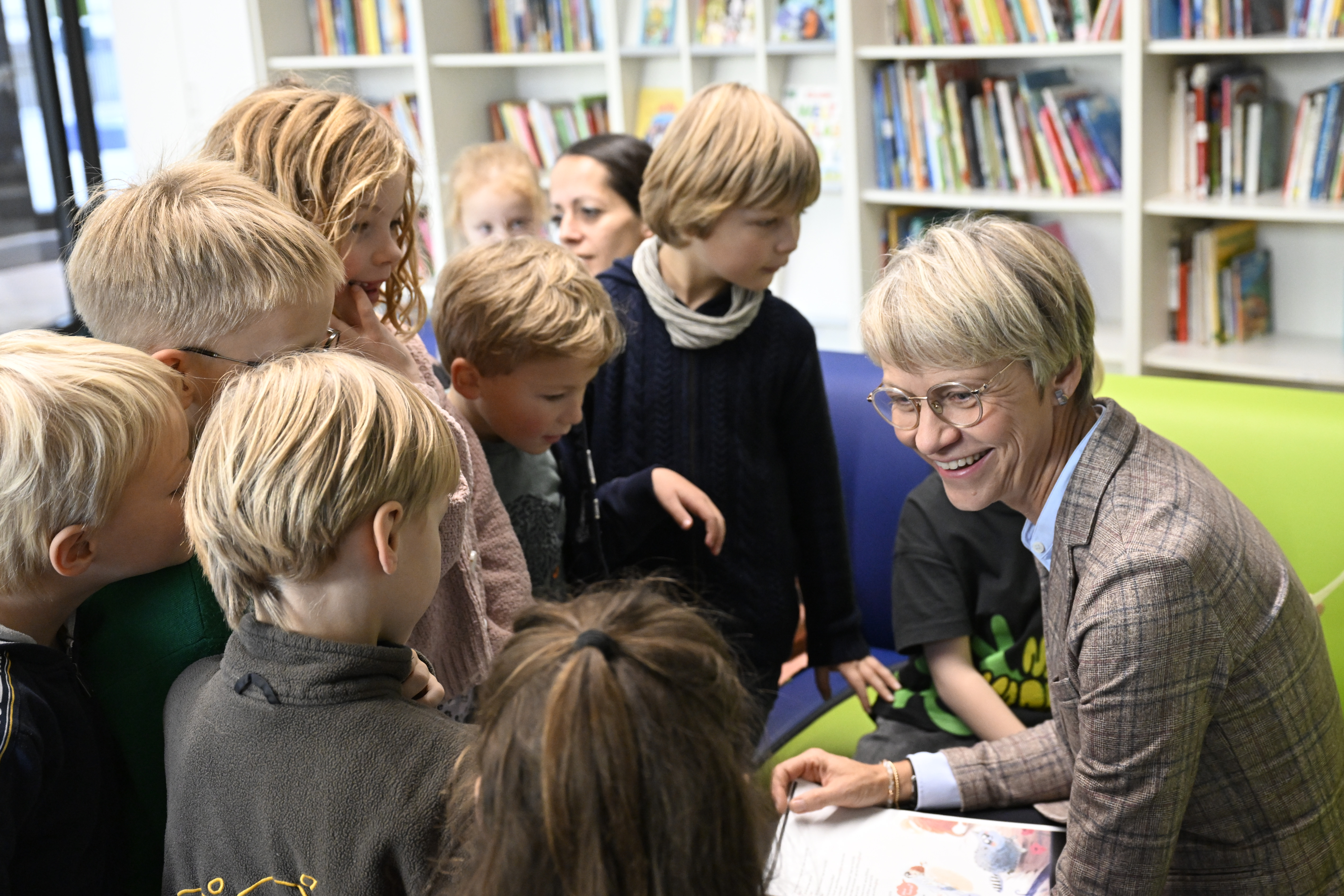 Schulministerin Dorothee Feller inmitten von Schülerinnen und Schülern der Kreuzschule in Münster zum Vorlesetag 2023.