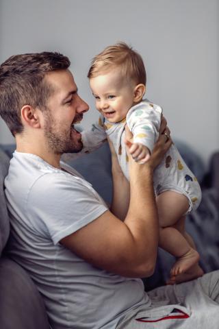 Eine Mutter hält ein lachendes Baby auf dem Schoß.