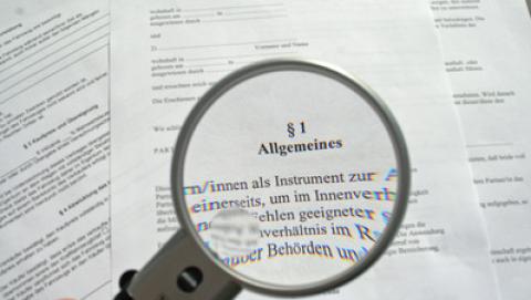 Lupe vor Gesetzestext.
