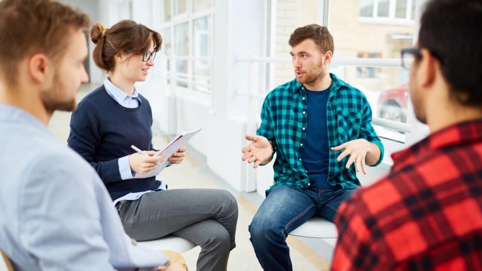 Beratungssituation, mehrere Personen sitzen in einem Kreis und sprechen miteinander. Beratungssituation, mehrere Personen sitzen in einem Kreis und sprechen miteinander.