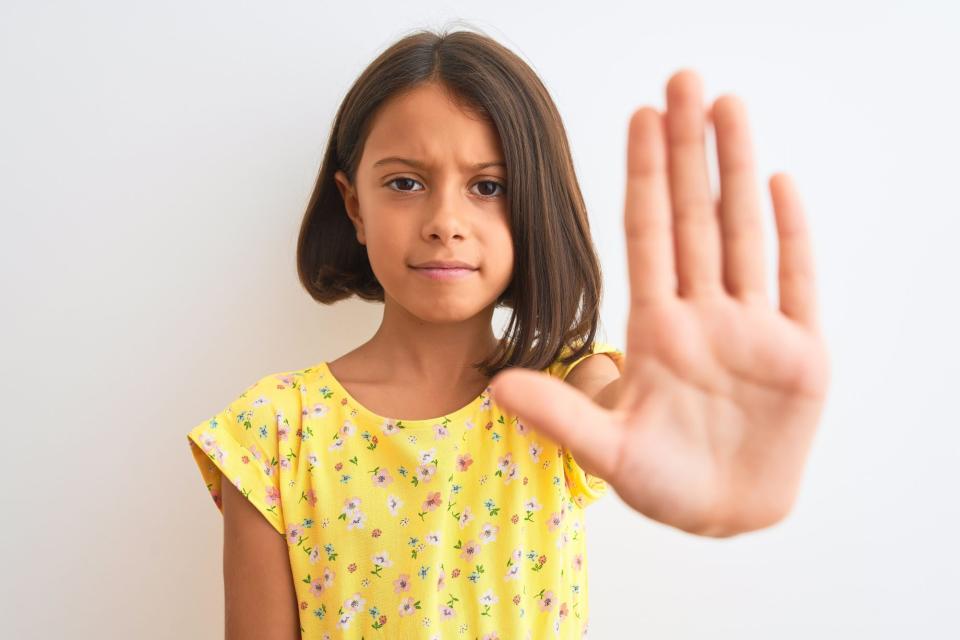 Mädchen hebt die Hand und signalisiert Stopp Mädchen hebt die Hand und signalisiert Stopp