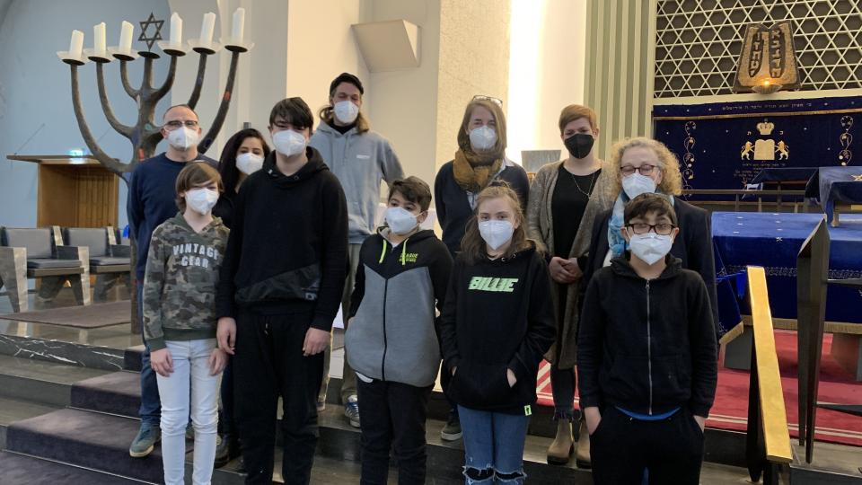 Eine Gruppe Jugendlicher steht in einer Synagoge. Eine Gruppe Jugendlicher steht in einer Synagoge.