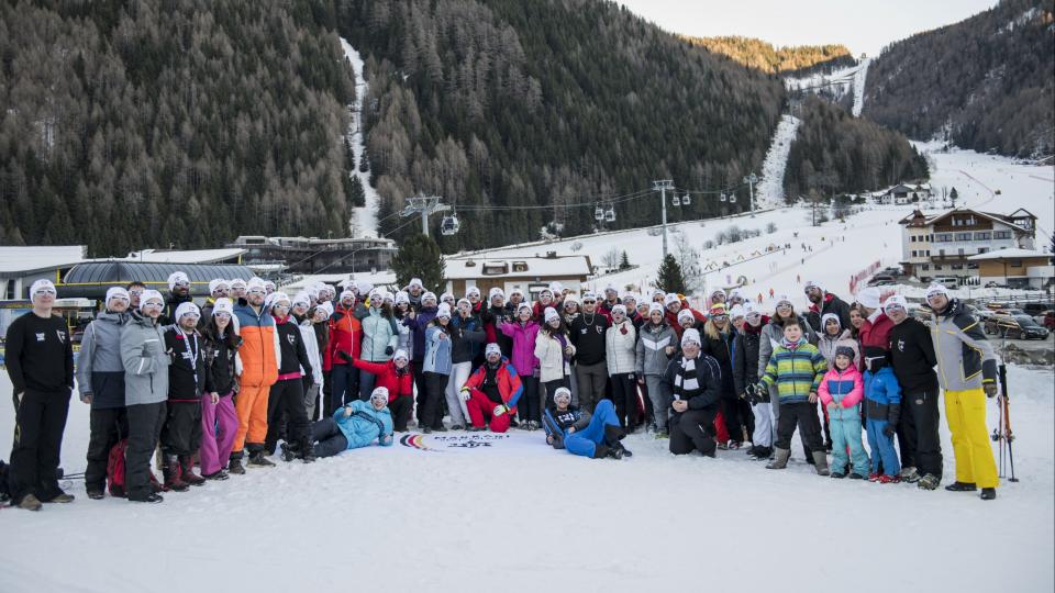 Eine Gruppe Wintersportlerinnen und -sportler in den verschneiten Bergen