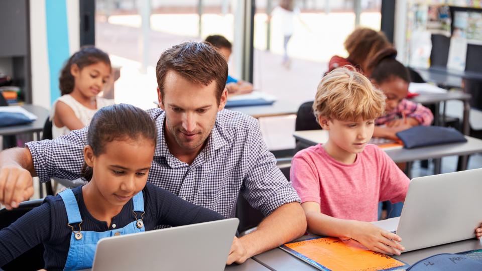 Lehrer und Grundschüler arbeiten Lehrer und Grundschüler arbeiten