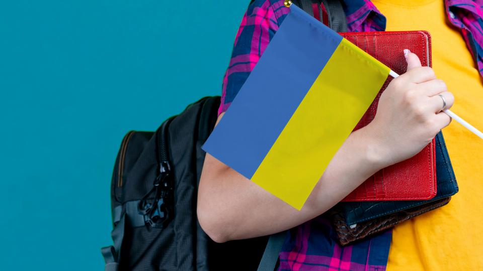 Schülerin mit Rucksack und Ukraine-Flagge Schülerin mit Rucksack und Ukraine-Flagge