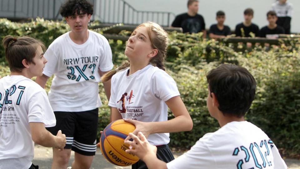 Ein gemischtes Team aus Mädchen und Jugend spielt Basketball bei der NRW3x3Tour.