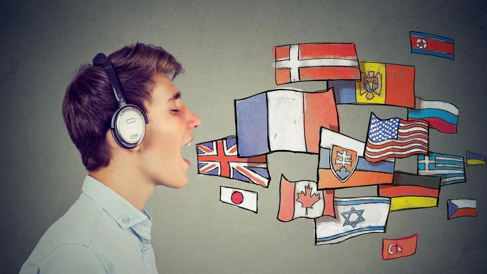 Junge mit Kopfhörern und geöffnetem Mund im Profil, neben seinem Mund grafische Darstellung verschiedener Landesflaggen. Junge mit Kopfhörern und geöffnetem Mund im Profil, neben seinem Mund grafische Darstellung verschiedener Landesflaggen.