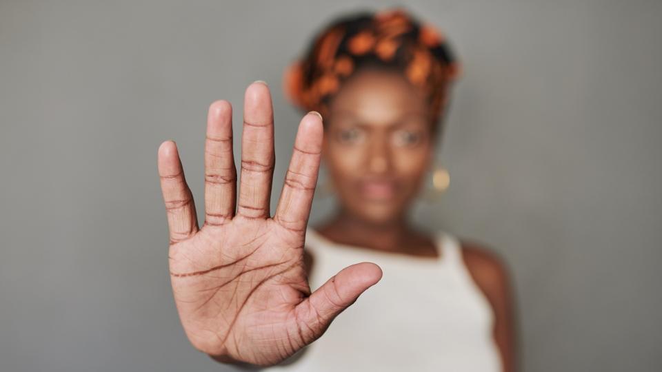 Jugendliche streckt abwehrend die Hand aus. Jugendliche streckt abwehrend die Hand aus.