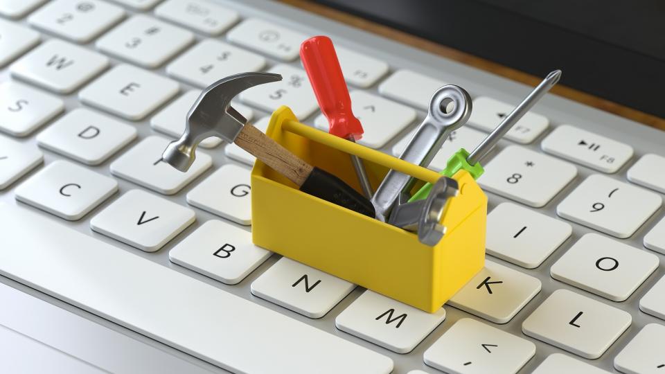 Auf einer Computertastatur steht ein Miniatur-Werkzeugkasten. Auf einer Computertastatur steht ein Miniatur-Werkzeugkasten.