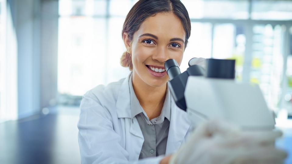 Junge Frau vor einem Laborgerät. Junge Frau vor einem Laborgerät.