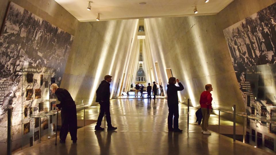 Besucherinnen und Besucher von Yad Vashem schauen sich die Ausstellung im Museum der Geschichte des Holocaustan.