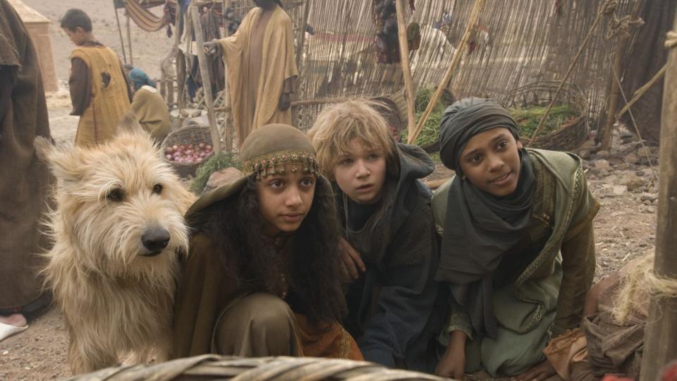 Drei Kinder und ein großer Hund in orientalischer Kleidung schauen erwartungsvoll in die Kamera. Drei Kinder und ein großer Hund in orientalischer Kleidung schauen erwartungsvoll in die Kamera.