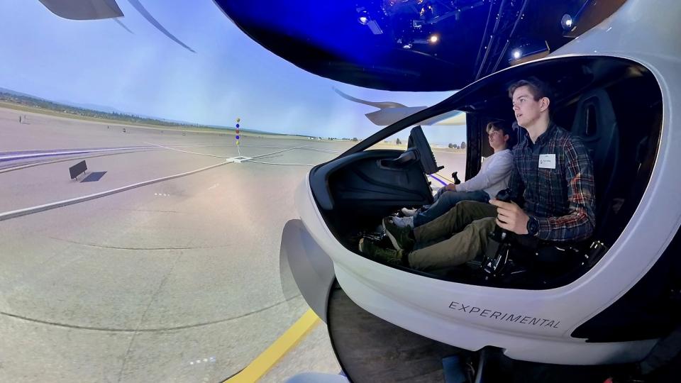 Zwei Schüler sitzen in einem Flugsimulator.