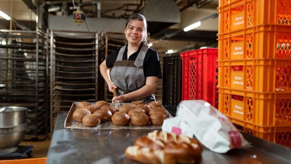 Eine Schüler arbeitet in einer Bäckerei mit. Eine Schüler arbeitet in einer Bäckerei mit.
