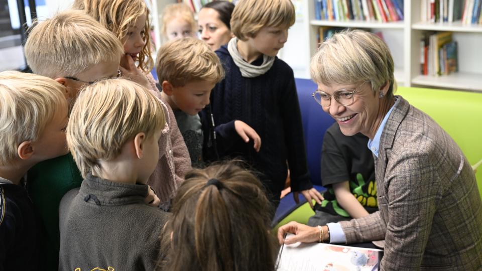 Schulministerin Dorothee Feller inmitten von Schülerinnen und Schülern der Kreuzschule in Münster zum Vorlesetag 2023.
