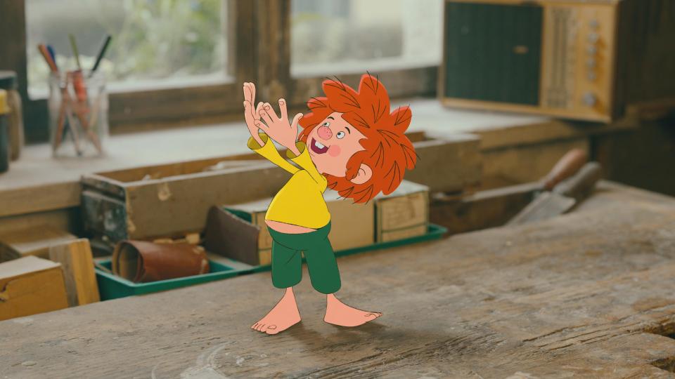 Pumuckl steht auf einem Holztisch