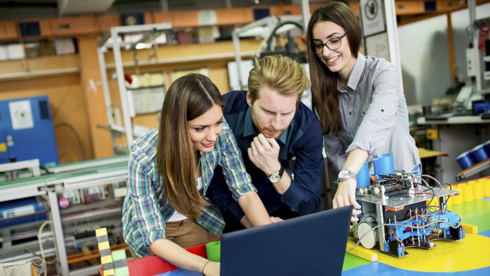 Drei Schülerinnen und Schüler arbeiten in einer Robotikwerkstatt. Drei Schülerinnen und Schüler arbeiten in einer Robotikwerkstatt.