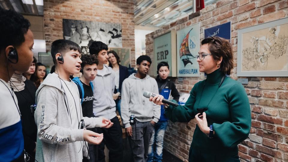 Schülerinnen und Schüler der Johannes-Rau-Hauptschule Bonn im Gespräch mit einer Mitarbeiterin, die durch die Ausstellung im Haus der Geschichte Bonn führt (22. Mai 2024).