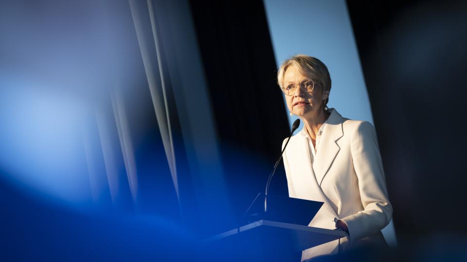 Ministerin Feller steht an einem Stehpult und spricht.