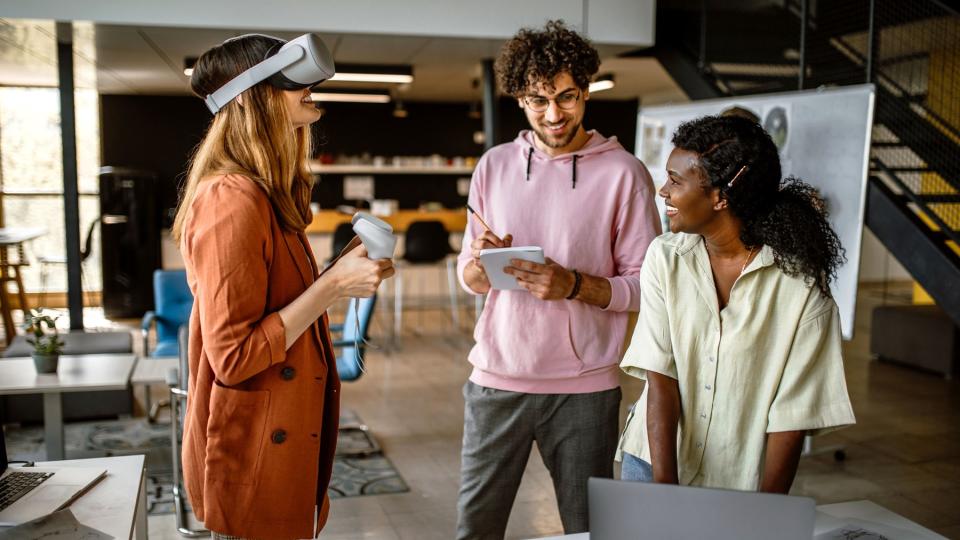 Drei junge Menschen arbeiten mit verschiedenen Medien, unter anderem mit einer VR-Brille. Drei junge Menschen arbeiten mit verschiedenen Medien, unter anderem mit einer VR-Brille.