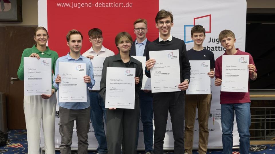 Die Teilnehmenden der Altersgruppen I und II halten ihre Urkunden in die Kamera. Die Teilnehmenden der Altersgruppen I und II halten ihre Urkunden in die Kamera.