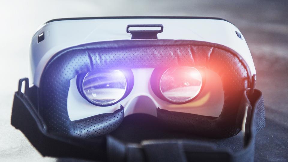 Eine VR Brille liegt auf einer glatten Oberfläche. Das Licht bricht sich in ihren Linsen. Eine VR Brille liegt auf einer glatten Oberfläche. Das Licht bricht sich in ihren Linsen.
