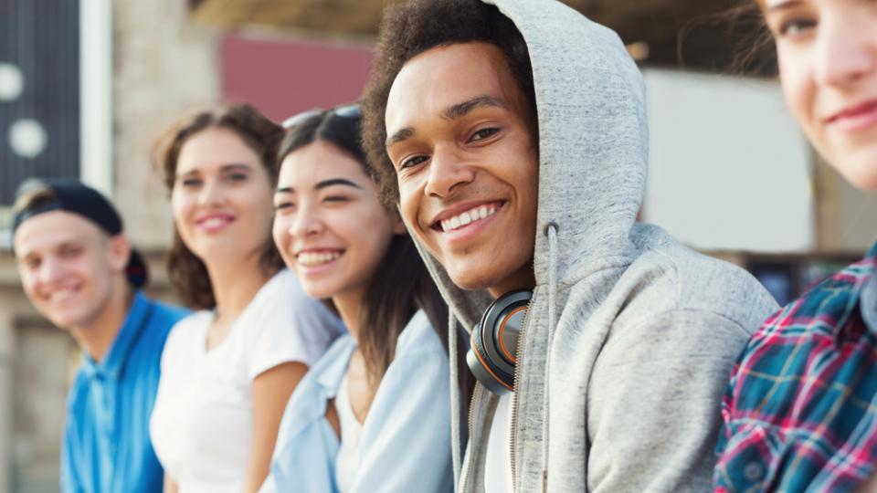 Junge Frauen und Männer lächeln in die Kamera. Junge Frauen und Männer lächeln in die Kamera.