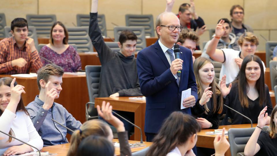 Der Landtagspräsident André Kuper spricht mit Schülerinnen und Schülern. Der Landtagspräsident André Kuper spricht mit Schülerinnen und Schülern.