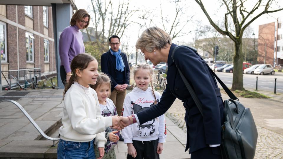 Ministerin Feller wird an der Bonifatiusschule von Veronica, Kira und Sima begrüßt.