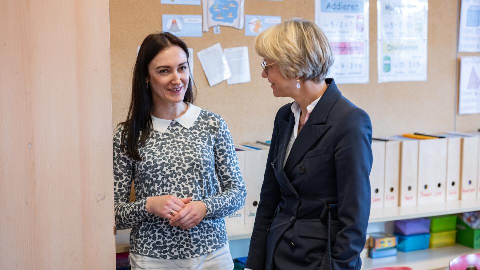 Julia Posokhova aus der Ukraine arbeitet als Alltagshelferin an der Bonifatiusschule Düsseldorf und spricht hier mit Ministerin Feller.