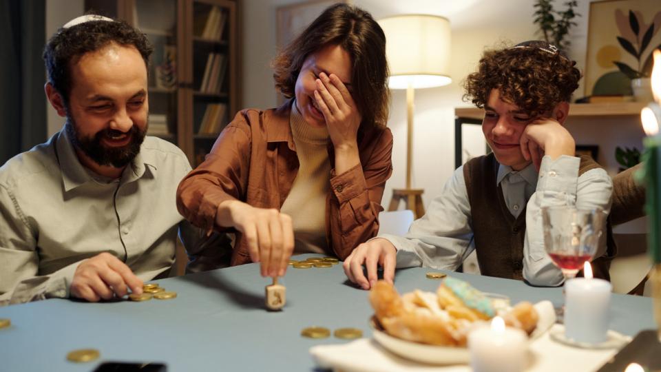Eine jüdische Familie sitzt an einem Tisch und spielt ein Spiel. Eine jüdische Familie sitzt an einem Tisch und spielt ein Spiel.
