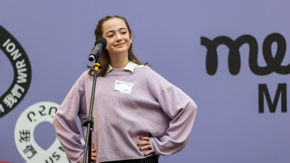 Eine Schülerin trägt im Finale ihren Beitrag zu "Mehr Sprachen - mehr WIR" vor. Eine Schülerin trägt im Finale ihren Beitrag zu "Mehr Sprachen - mehr WIR" vor.