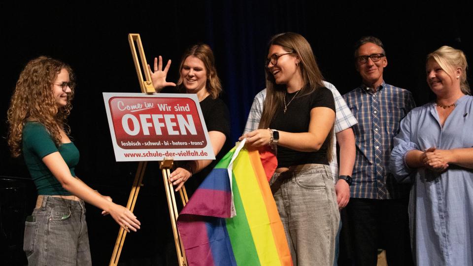 Schülerinnen und Schüler des OHG Monheim enthüllen die Schule der Vielfalt-Plakette.
