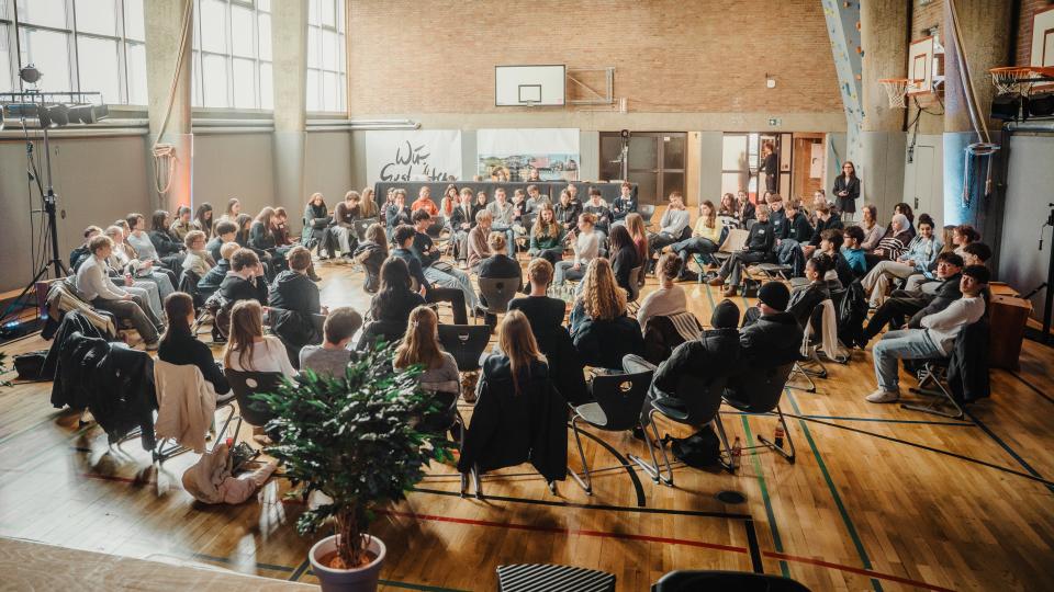 Fishbowl-Diskussion in einer Sportaula mit Holzboden