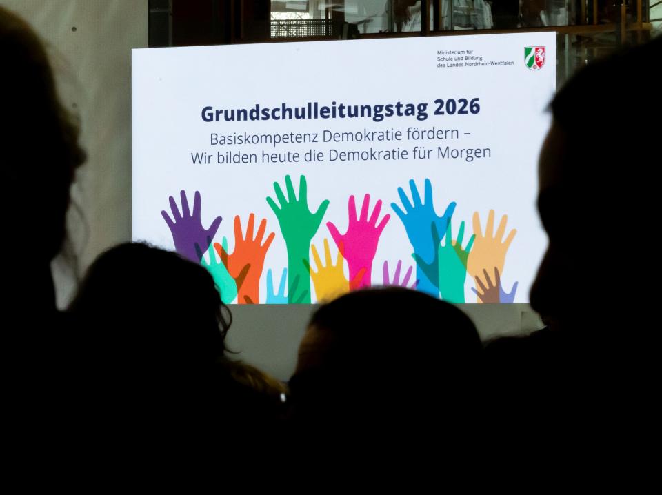 Plakat des Grundschulleitungstags 2026, im Vordergrund schemenhaft Personen. 