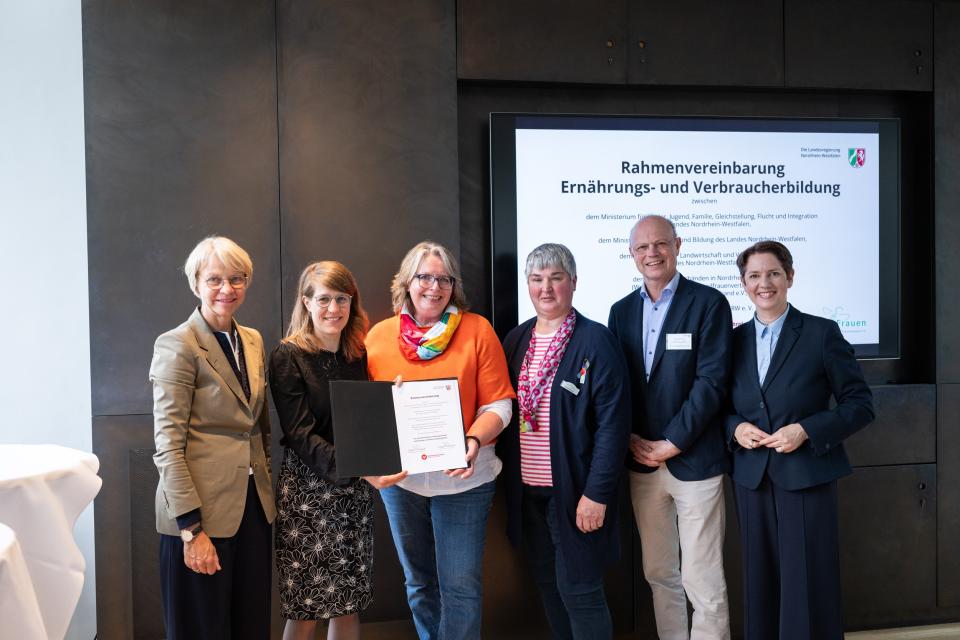 Partnerinnen und Partner zeigen die unterzeichnete Rahmenvereinbarung.