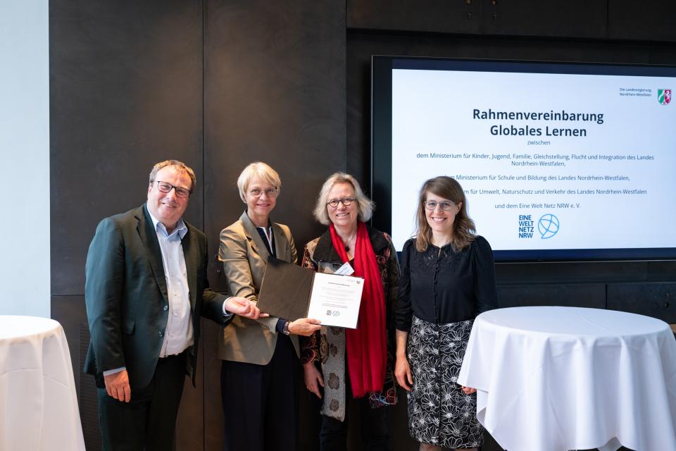 Partnerinnen und Partner zeigen die unterzeichnete Rahmenvereinbarung.