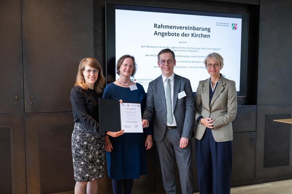 Partnerinnen und Partner zeigen die unterzeichnete Rahmenvereinbarung.