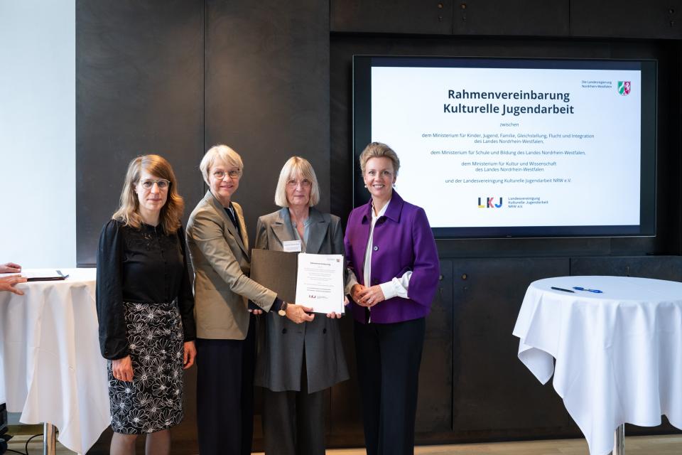 Partnerinnen und Partner zeigen die unterzeichnete Rahmenvereinbarung.