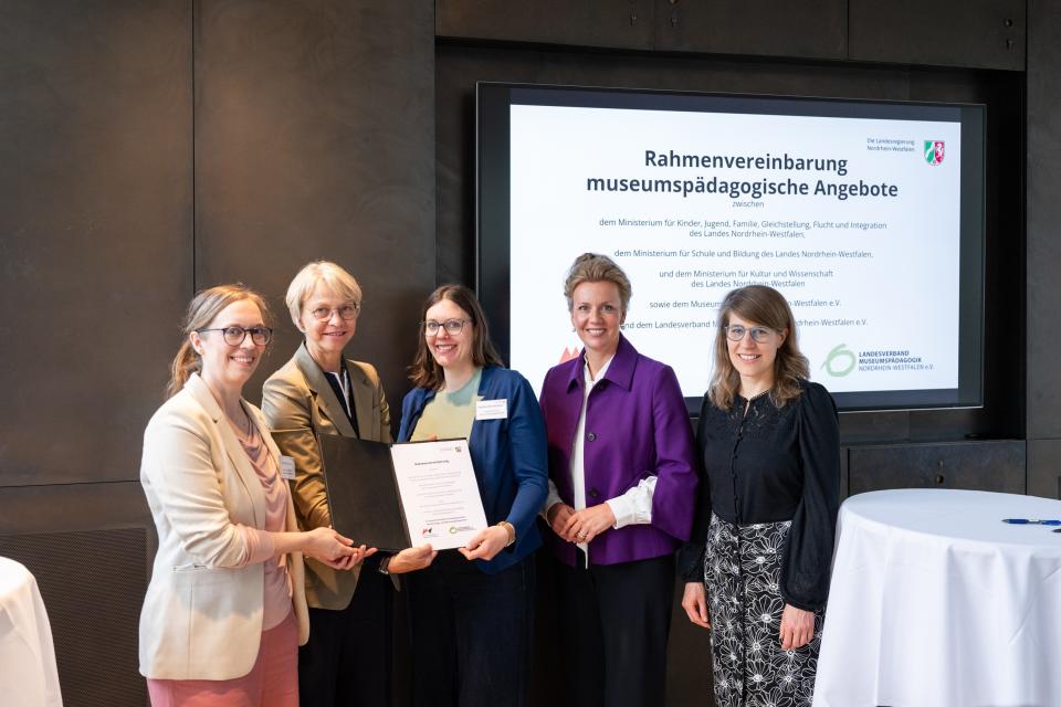 Partnerinnen und Partner zeigen die unterzeichnete Rahmenvereinbarung.