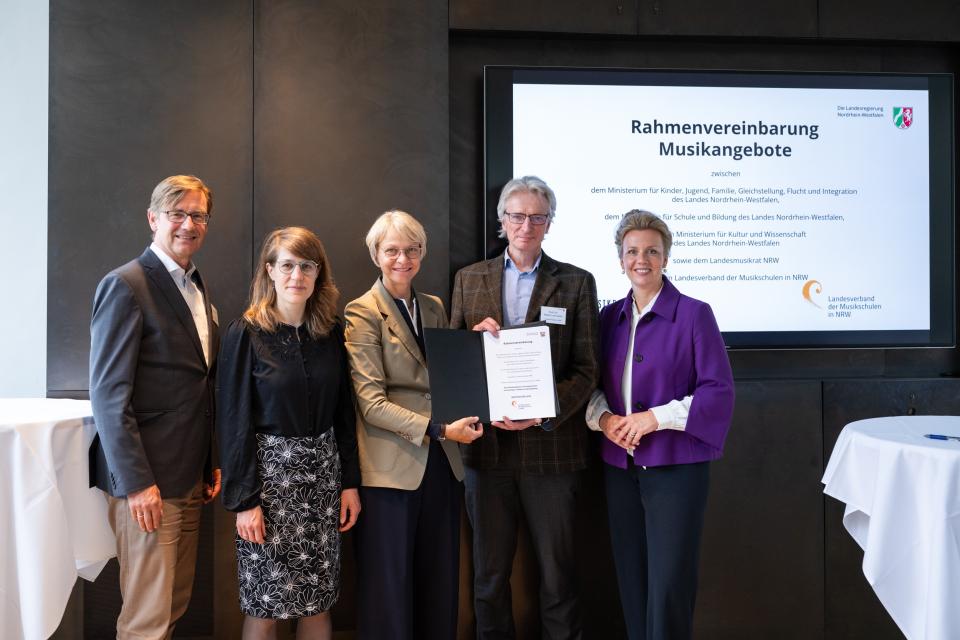 Partnerinnen und Partner zeigen die unterzeichnete Rahmenvereinbarung.