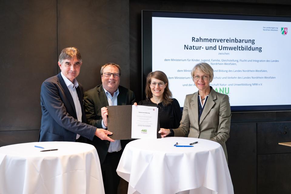 Partnerinnen und Partner zeigen die unterzeichnete Rahmenvereinbarung.