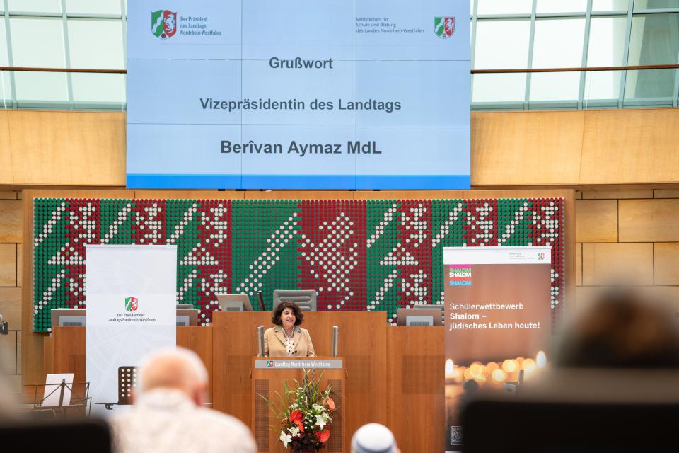 Berivan Aymaz steht vor dem Rednerpult im Landtag und hält ein Grußwort.