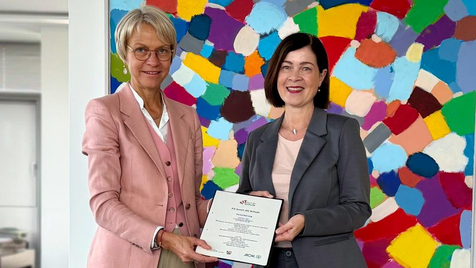 Schulministerin Dorothee Feller und AOK-Vorstandsmitglied Sabine Deutscher zeigen die unterzeichnete Kooperationsvereinbarung „Fit durch die Schule“.