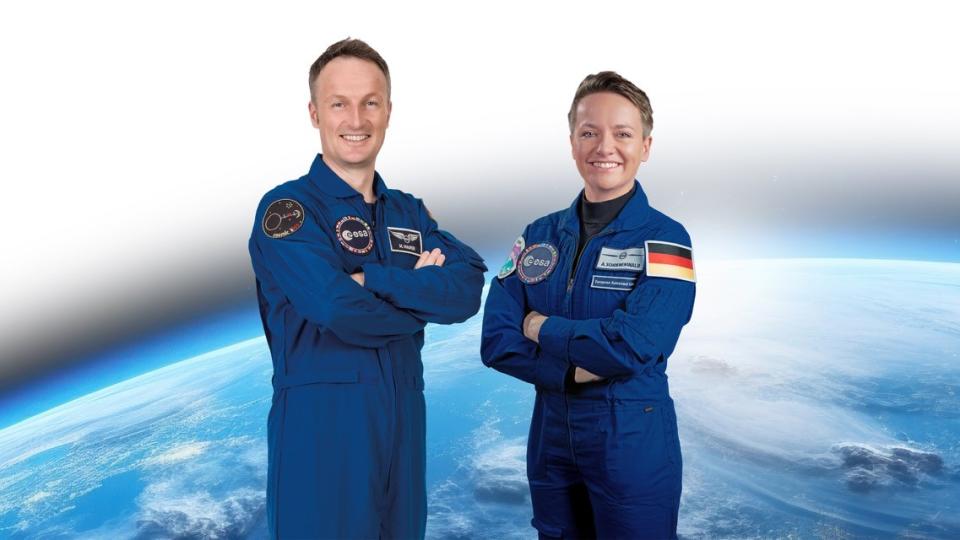Die Astronautin Amelie Schoenenwald und der Astronaut Mathias Maurer der ESA stehen vor der Erdkugel.