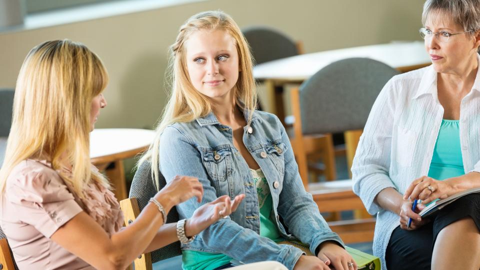 Zwei Frauen unterhalten sich mit einer Jugendlichen. Zwei Frauen unterhalten sich mit einer Jugendlichen.
