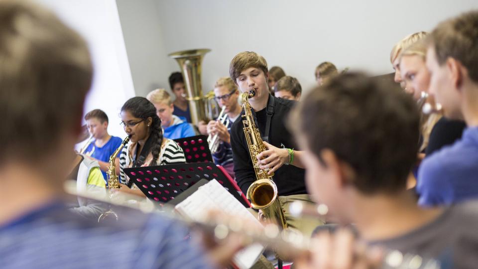 Schüler üben im Musikunterricht ein Musikstück ein. Blasorchester.