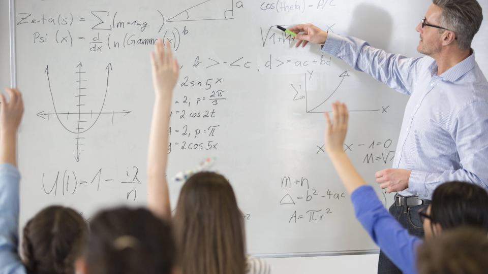 Lehrer mit Schulklasse im Unterricht. Auf der Tafel sind Erklärungen zum Fach Physik zu erkennen. Lehrer mit Schulklasse im Unterricht. Auf der Tafel sind Erklärungen zum Fach Physik zu erkennen.