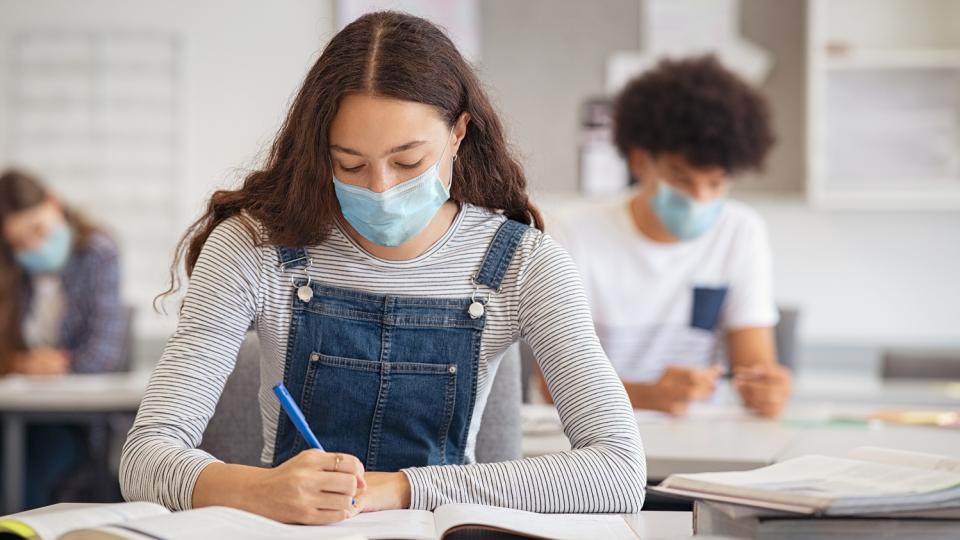 Schülerin mit medizinischem Mund-Nasenschutz im Unterricht Schülerin mit medizinischem Mund-Nasenschutz im Unterricht