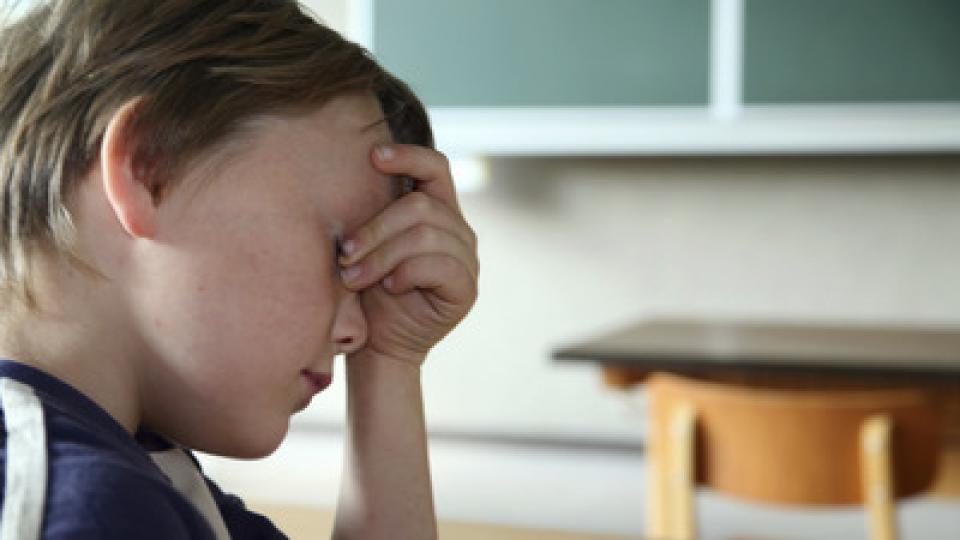 Ein junge birgt traurigen Blickes seine Stirn und seine Augen in seiner aufgestützten Hand. Ein junge birgt traurigen Blickes seine Stirn und seine Augen in seiner aufgestützten Hand.